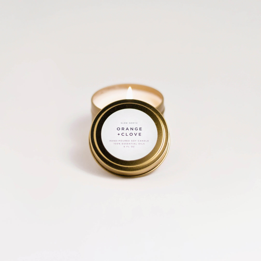 Orange clove travel tin candle with warm orange and clove scent.