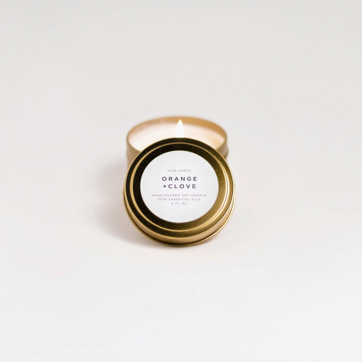 Orange clove travel tin candle with warm orange and clove scent.