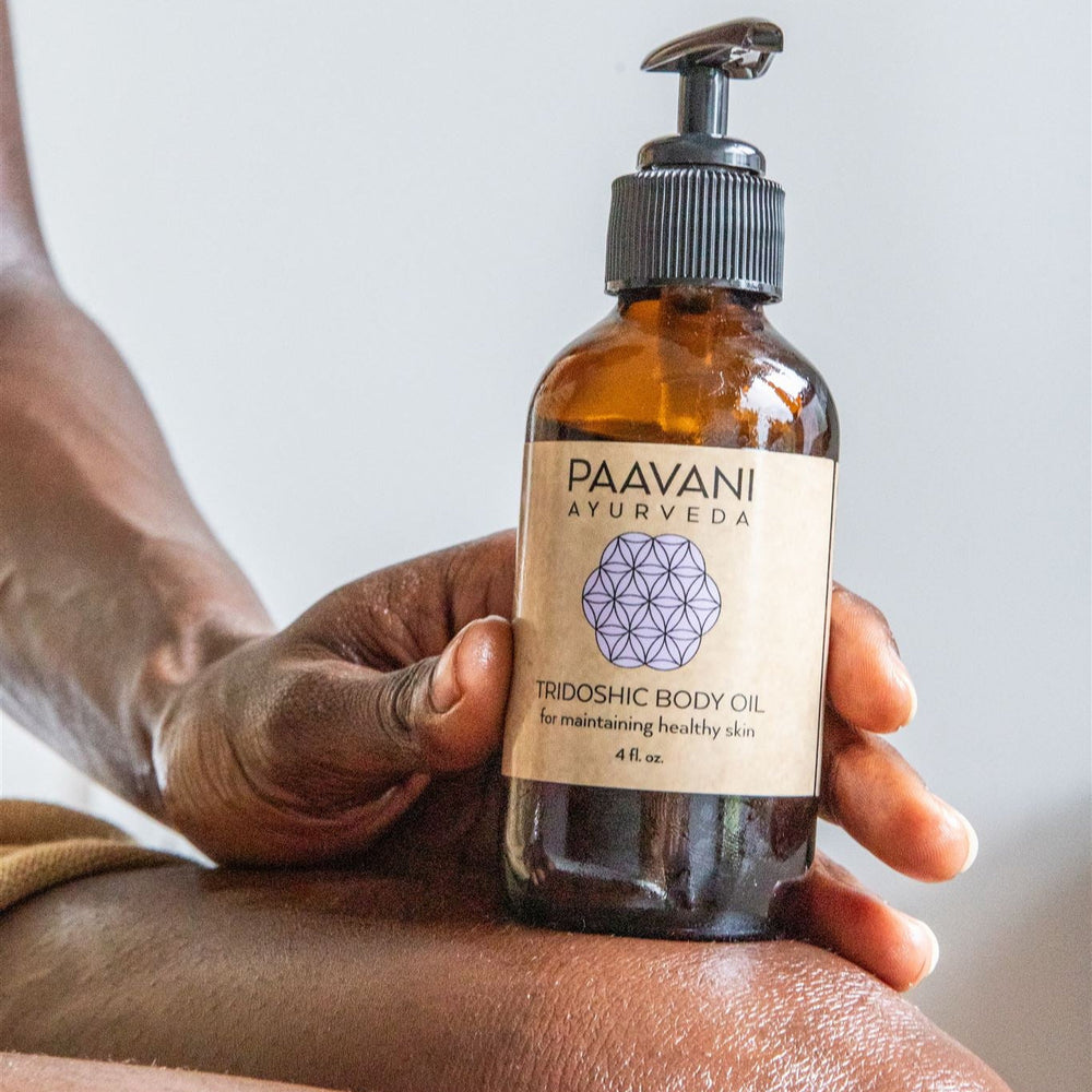 Tridoshic Ayurvedic body oil in a glass bottle with dropper.