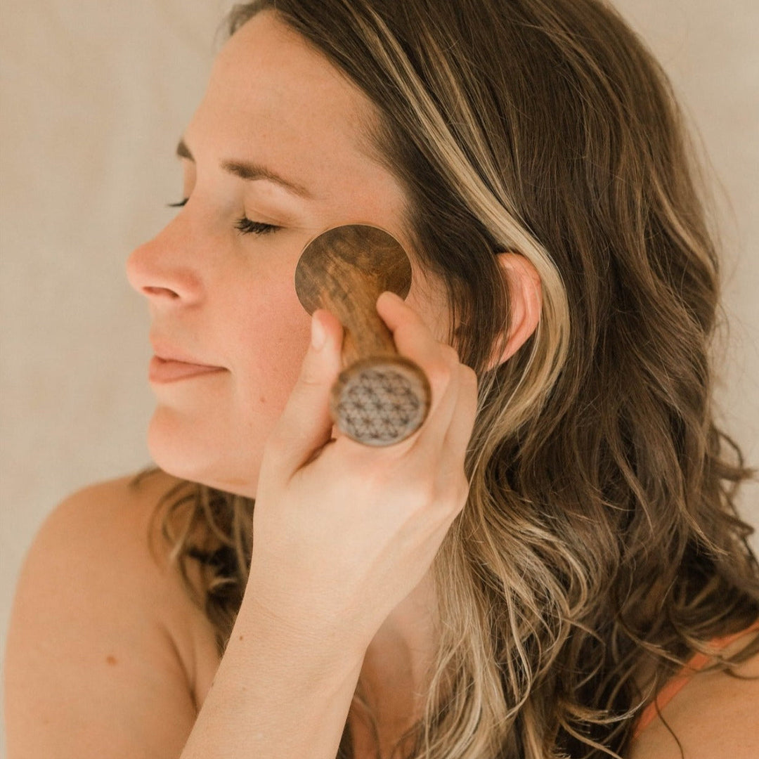 Kansa wand facial tool, handcrafted, on a plain background.