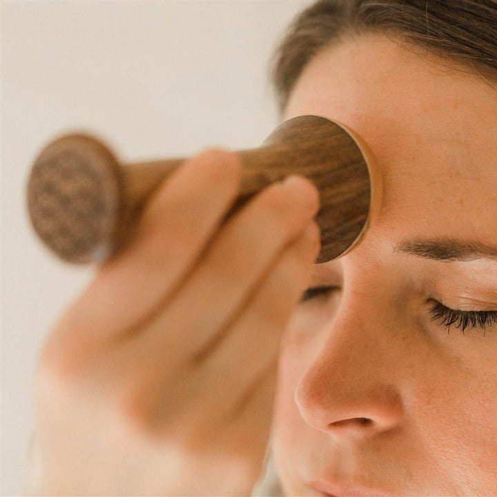 Kansa wand facial tool with a smooth, rounded shape for facial massage.
