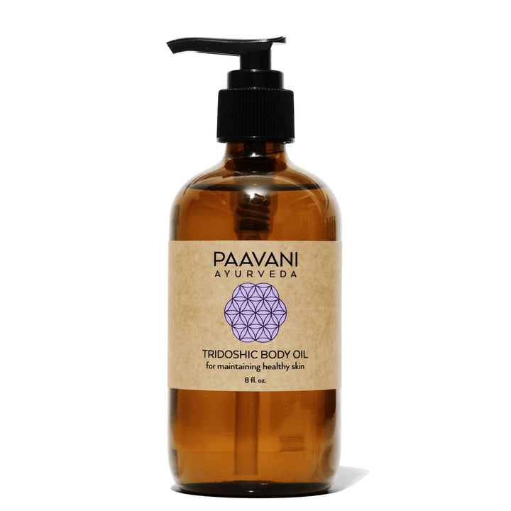 Bottle of tridoshic Ayurvedic body oil with herbal ingredients.