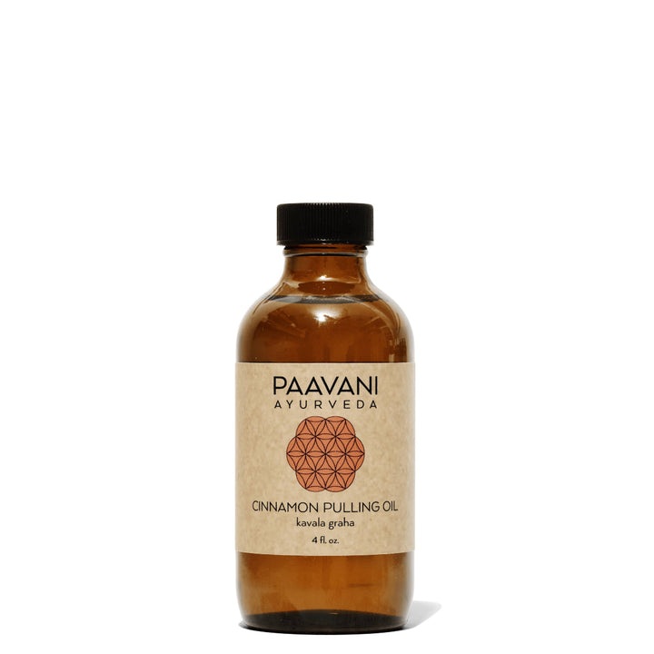 Glass bottle of cinnamon Ayurvedic oil-pulling blend with cinnamon and herbs.