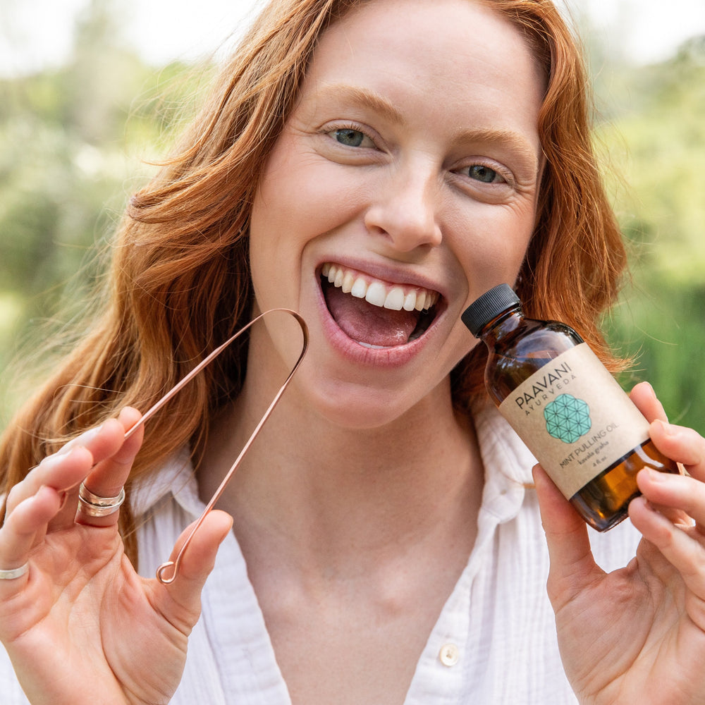 Ayurvedic oral care kit with tongue scraper and herbal pulling oil for the morning routine.
