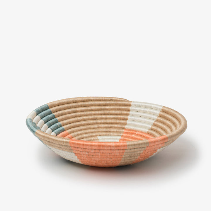 Medium Prism woven bowl in coral and teal sisal with a colorful pinwheel pattern.