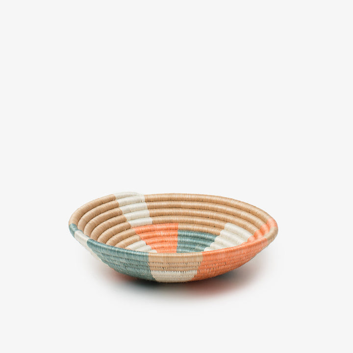 Small Prism woven bowl in coral, teal, and cream sisal with a pinwheel pattern.