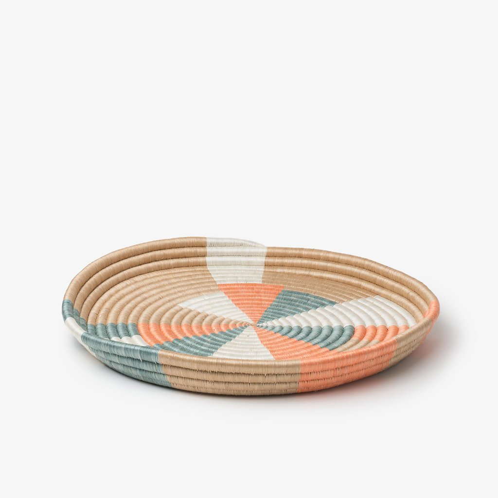 Large Prism woven tray in teal and coral sisal with a radiating pinwheel pattern.