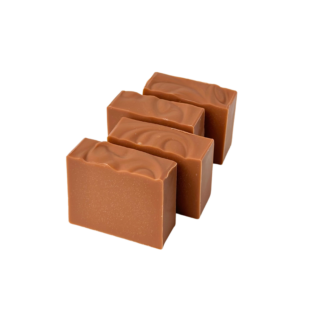 Four cold-process bar soaps shown as a package-free set with earthy, handcrafted appearance.
