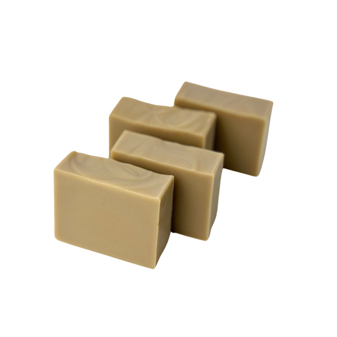 Assortment of four handmade soap bars displayed on a neutral background.