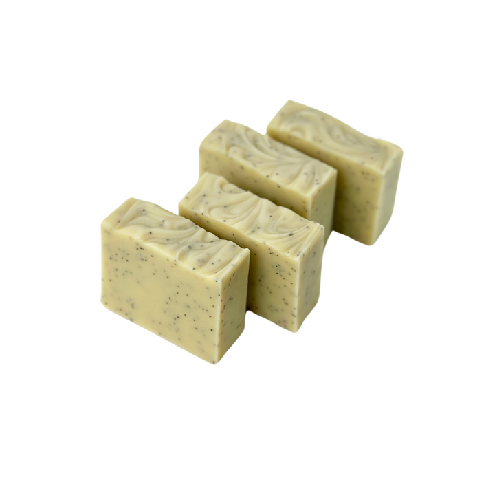 Set of four natural bar soaps in kraft paper packaging with assorted scents and textures.