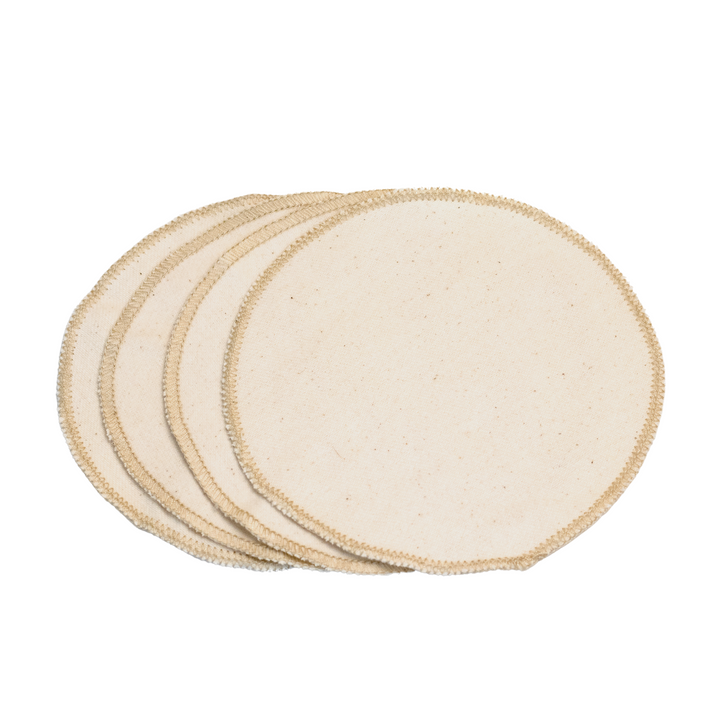Set of four organic cotton flannel facial cloths displayed in a natural setting.