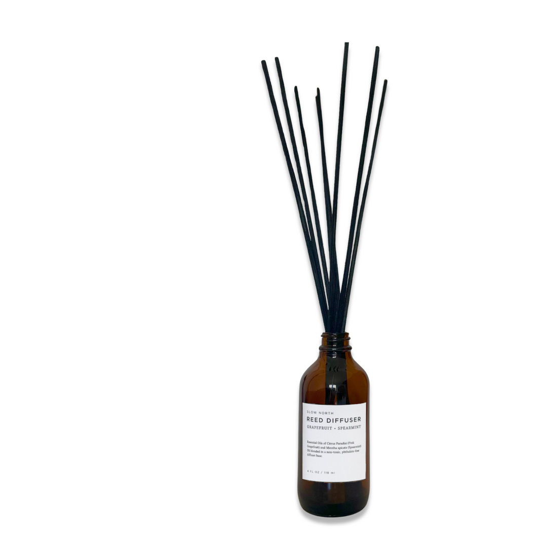 Grapefruit spearmint reed diffuser in a clear glass bottle with natural rattan reeds.