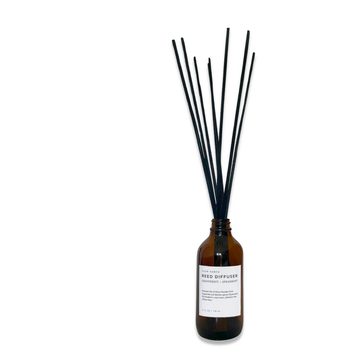 Grapefruit spearmint reed diffuser in a clear glass bottle with natural rattan reeds.