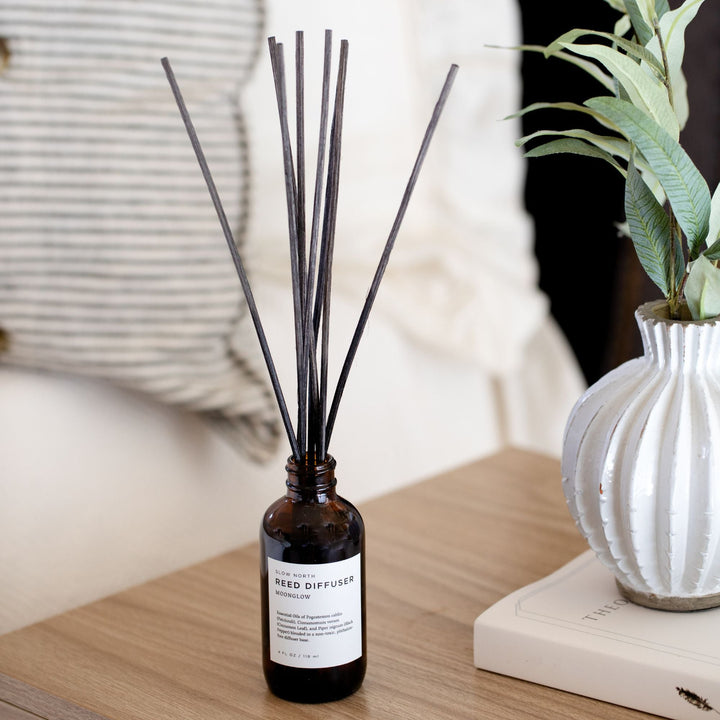 Moonglow reed diffuser with patchouli cinnamon scent in a glass bottle with rattan reeds.