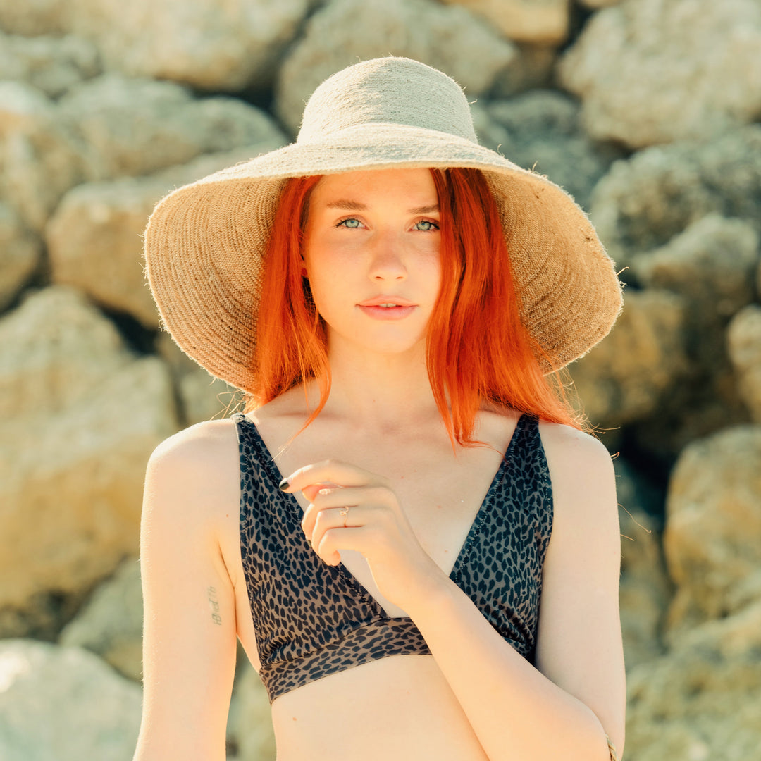 Natural beige handwoven jute hat featuring a wide brim and textured design.