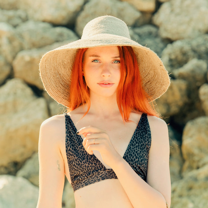 Natural beige handwoven jute hat featuring a wide brim and textured design.