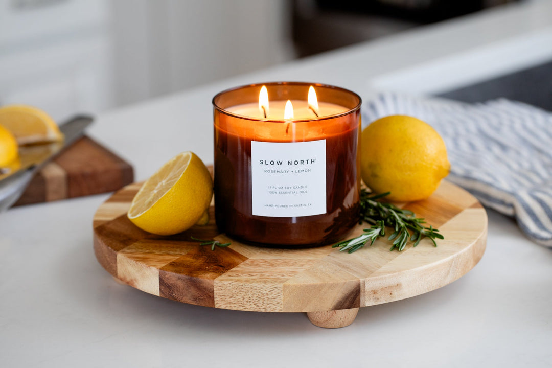Rosemary Lemon three-wick candle with a clear label and lit wicks.