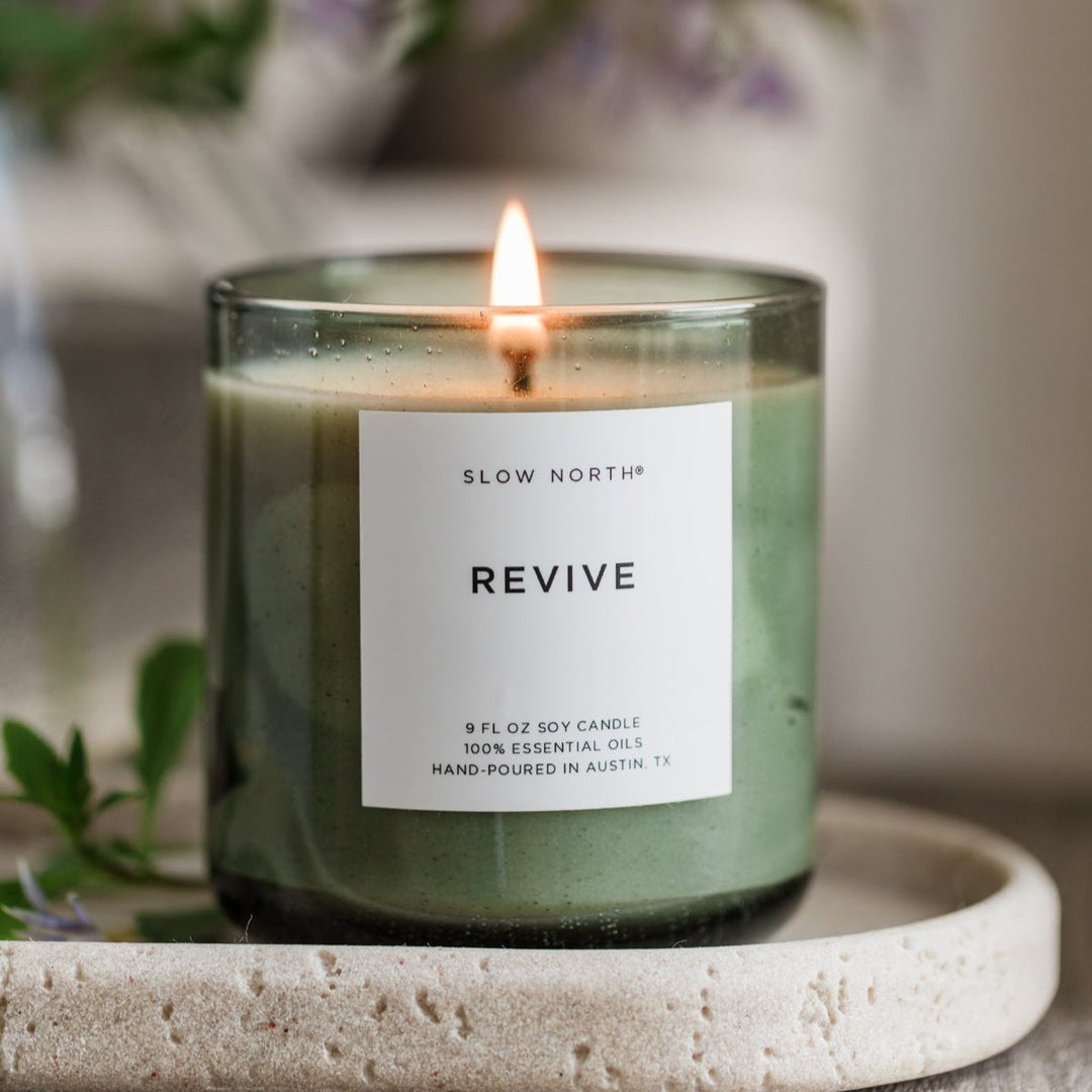 Revive Spa Collection candle in a green bubble glass vessel with a calming flame.