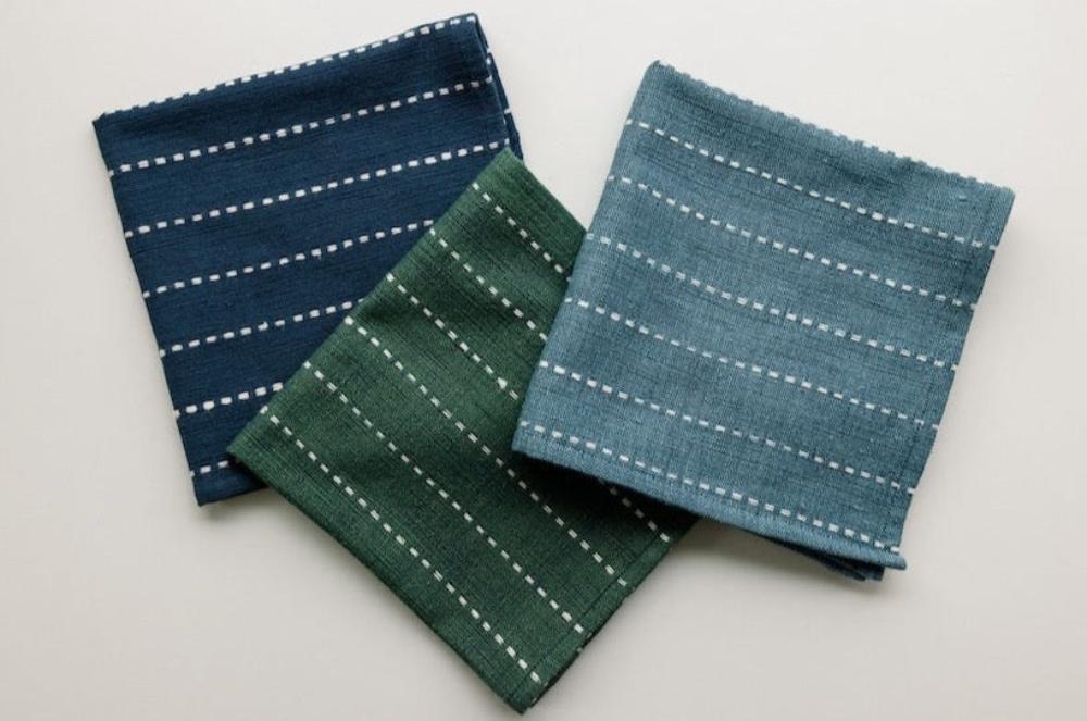 Navy, cedar and steel blue cocktail napkins laid together