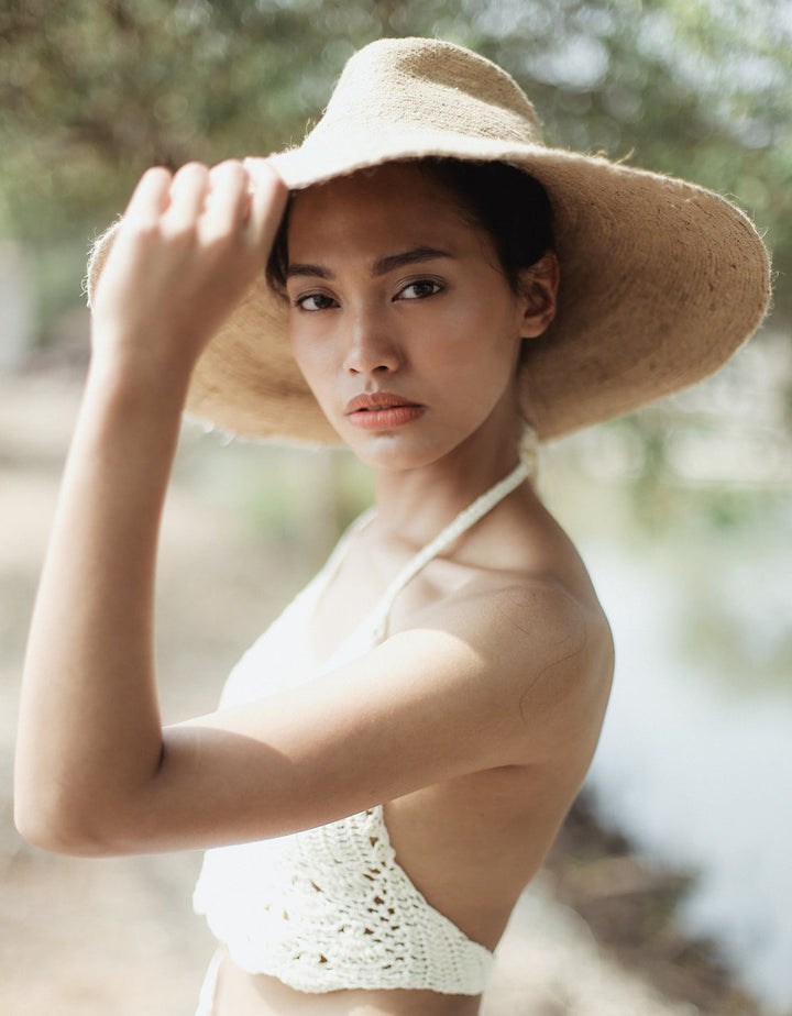 Handwoven jute hat in natural beige featuring a wide brim and stylish sun coverage.