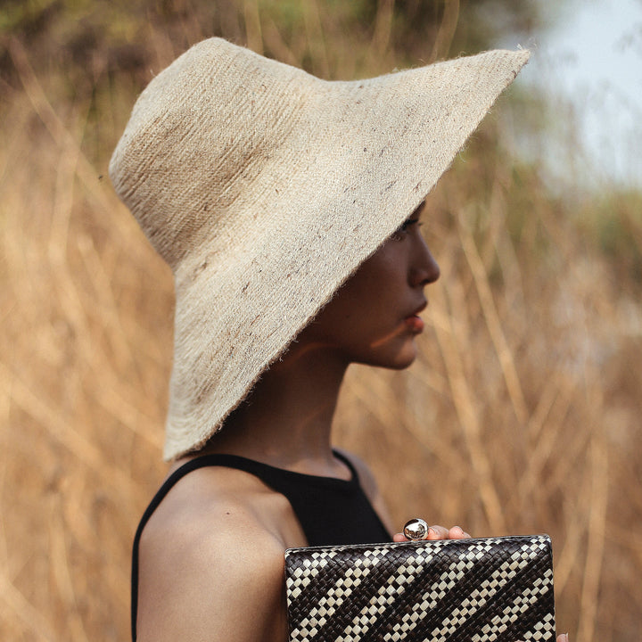 Handwoven jute hat in natural beige, a stylish wide-brim sun hat showing woven texture and casual elegance.