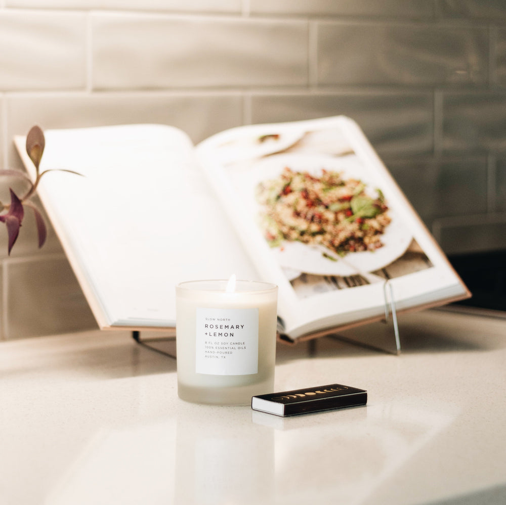 8 oz Rosemary Lemon signature candle with lit wick and lemon-rosemary scent.