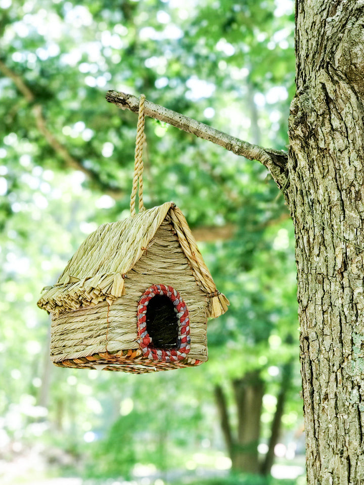 Handcrafted seagrass birdhouse cabin with raffia-thatch roof, recycled sari accents, hanging loop