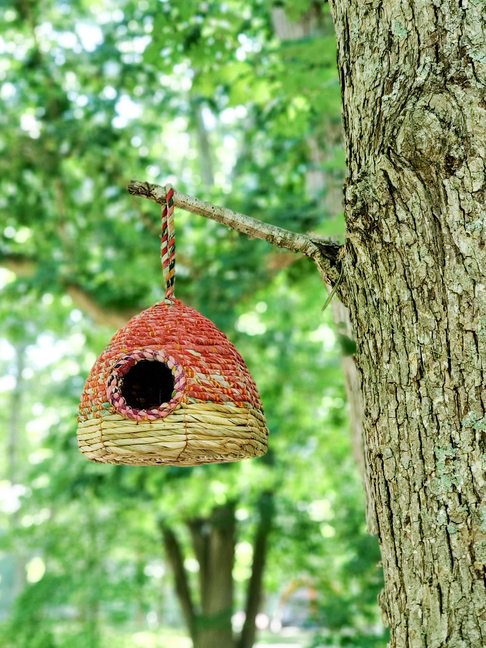 Vibrant coral sari birdhouse, domed beehive form, with sari-wrapped hanging loop