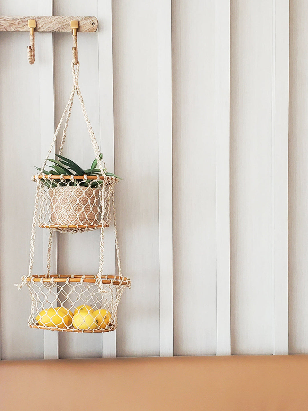 Double hanging basket made of natural jute with metal hooks, suitable for indoor or outdoor plant displays.