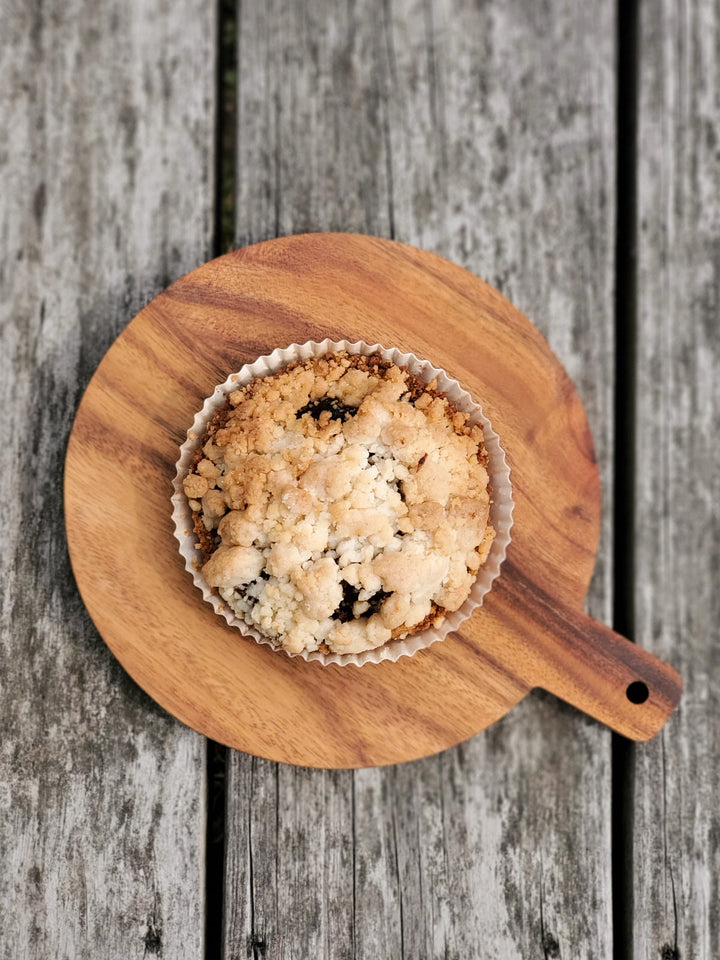 Hand-carved Albizia wood round board with built-in handle, sized for intimate gatherings
