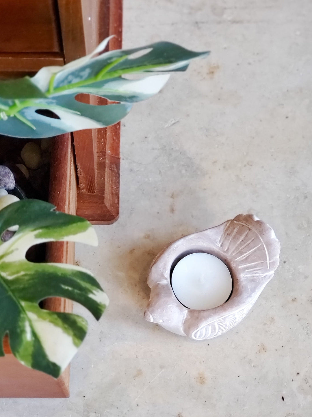 Rustic bird terracotta candle holder casting a warm glow