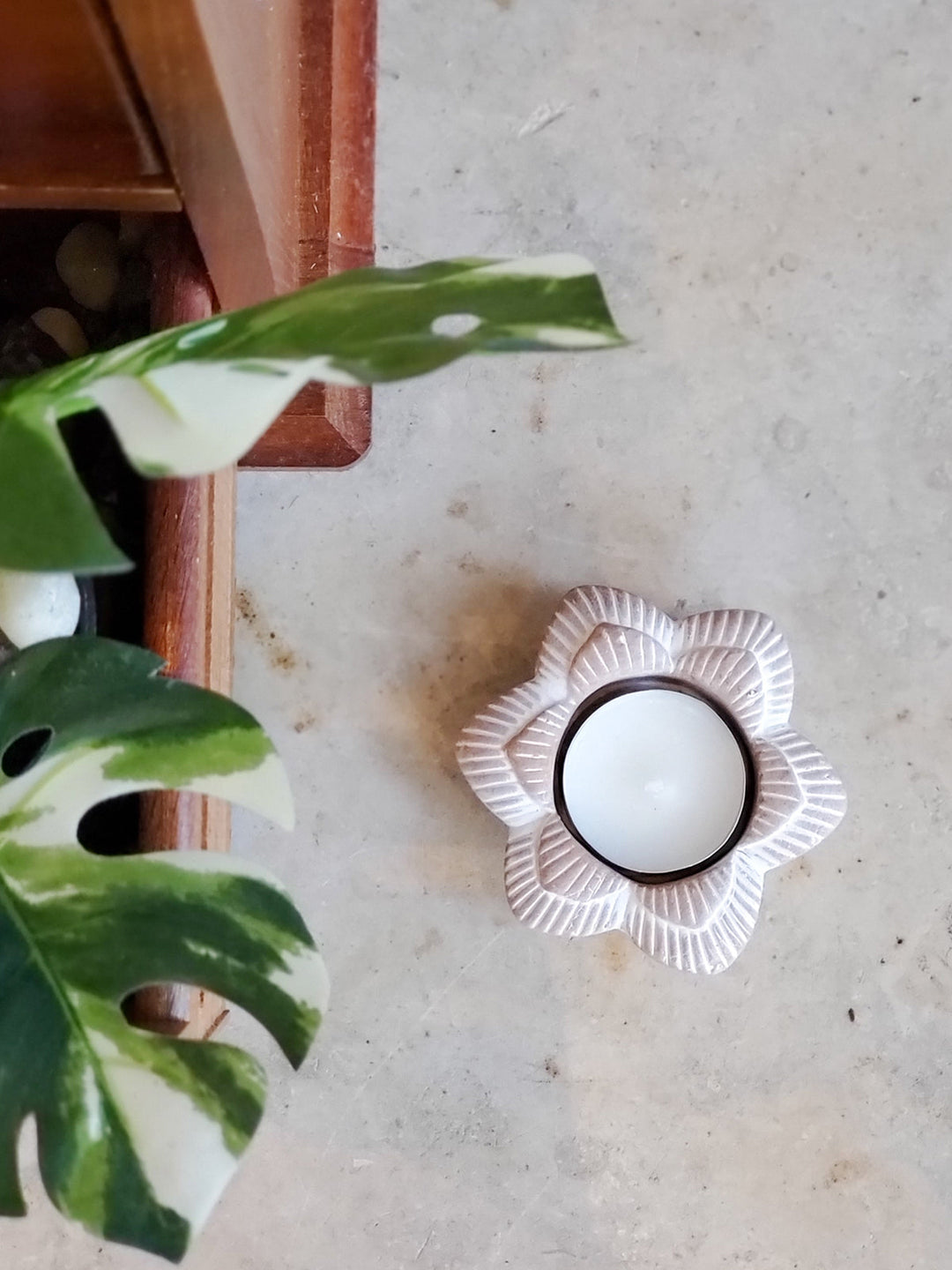 Flower terracotta tea light holder styled on a neutral background