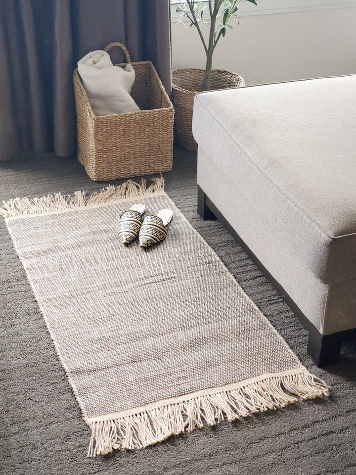 Gray braided jute rug, handwoven natural fiber with fringe detail