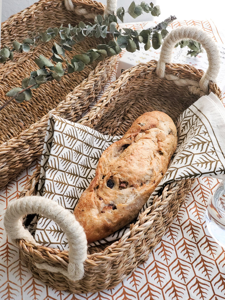 Natural seagrass bread basket with white handles, handwoven for serving bread