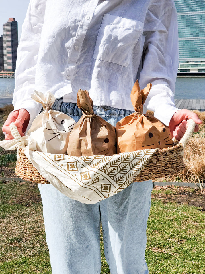 Natural seagrass bread baskets with white handles, styled with fresh bread