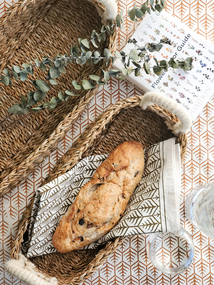 Handwoven natural seagrass bread basket with white handles in large and small sizes