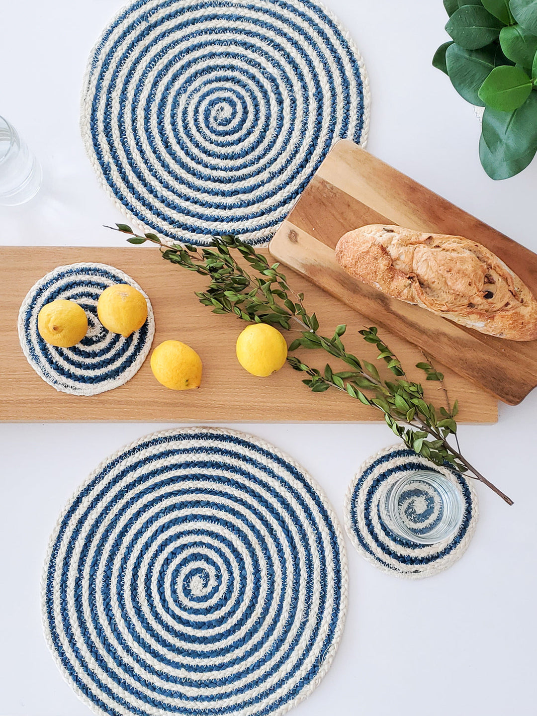 Blue round Kata Spiral placemat from DC-KORISSA featuring a coiled spiral design, perfect for table setting decor.