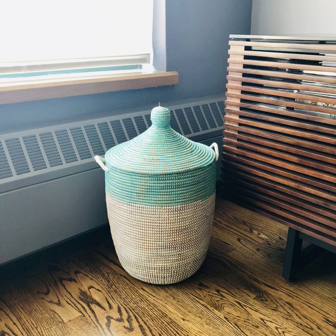 Turquoise and white two-tone woven basket with handles for storage.