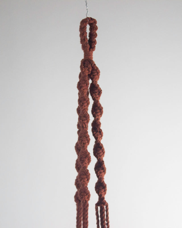 Tile-red Santana macrame plant holder with intricate knot detail.