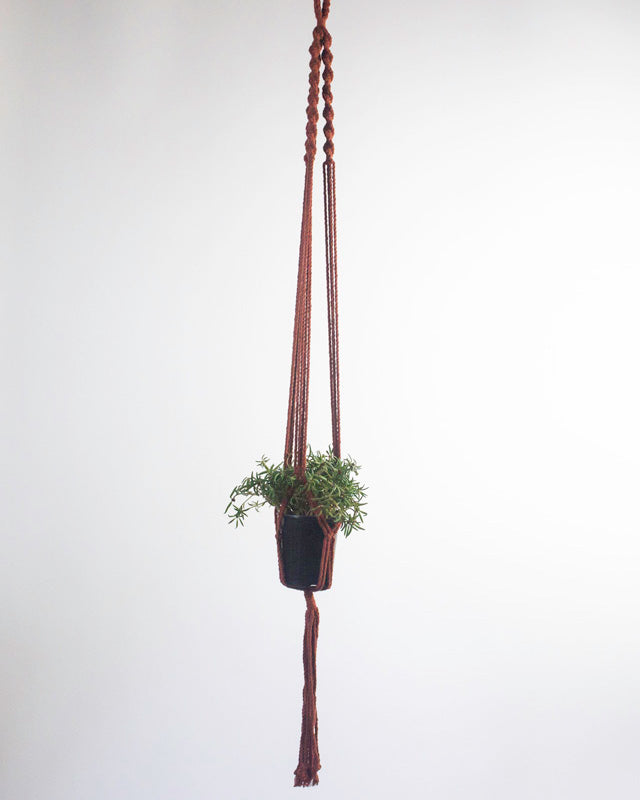 Tile-red Santana macrame plant holder styled with home decor.
