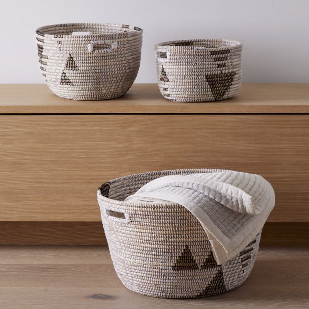Set of three black and white graphic print oval storage baskets.