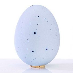 Egg-shaped porcelain salt shaker with a cork top, minimalist design.