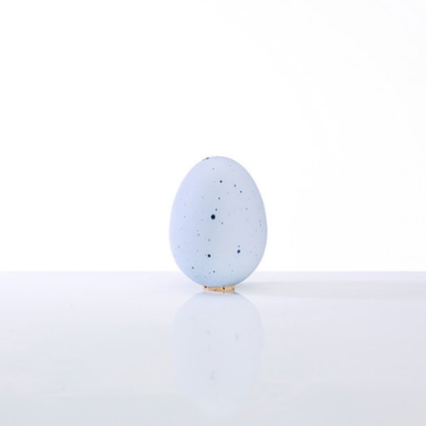 Egg-shaped porcelain salt shaker with a cork top, smooth finish.