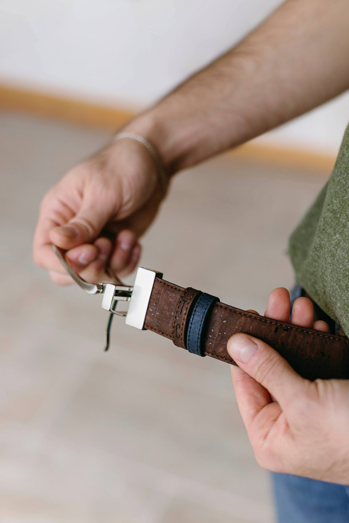 Reversible cork belt with brown and navy sides and a buckle, a versatile design.