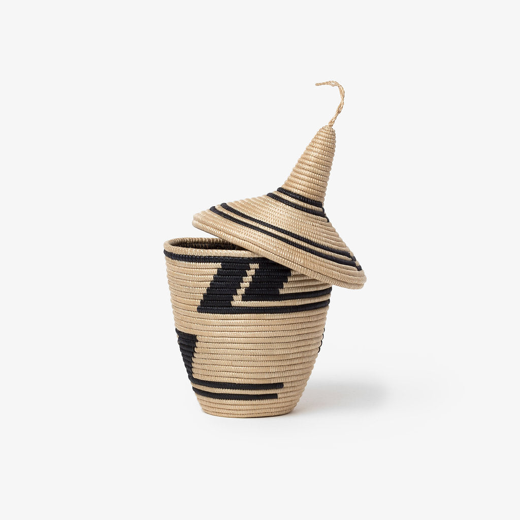 Black and tea sisal peace basket with a handle and intricate woven design.