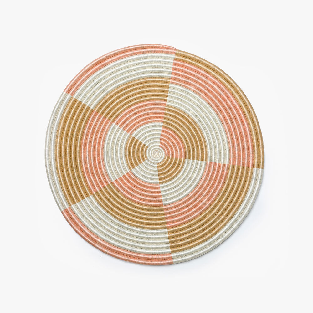 Large round blush flat woven wall hanging in sisal, shown overhead.