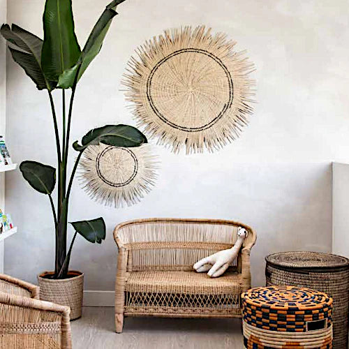 Woven sun circle wall medallion in natural fiber, round textured decor.