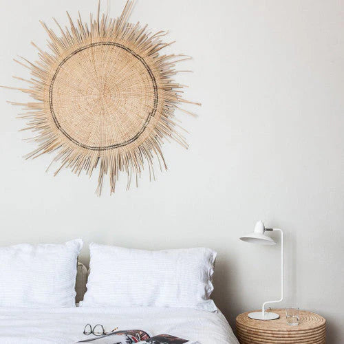 Natural woven sun circle wall art, a round sunburst wall piece.
