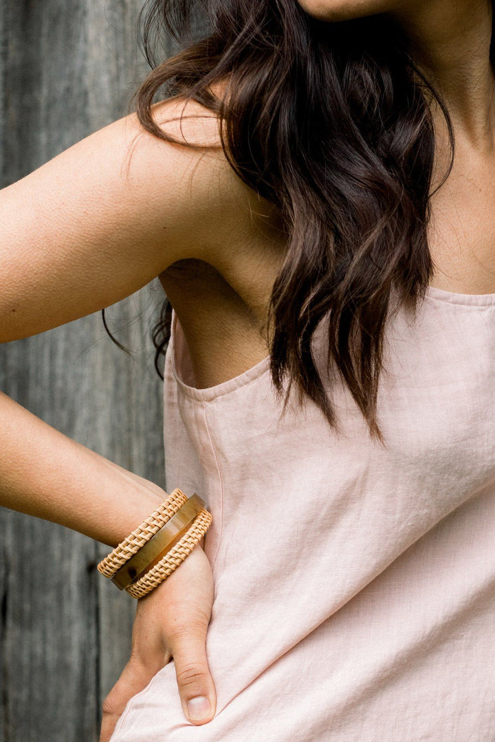 Set of buffalo horn and rattan bangles in natural earthy tones.