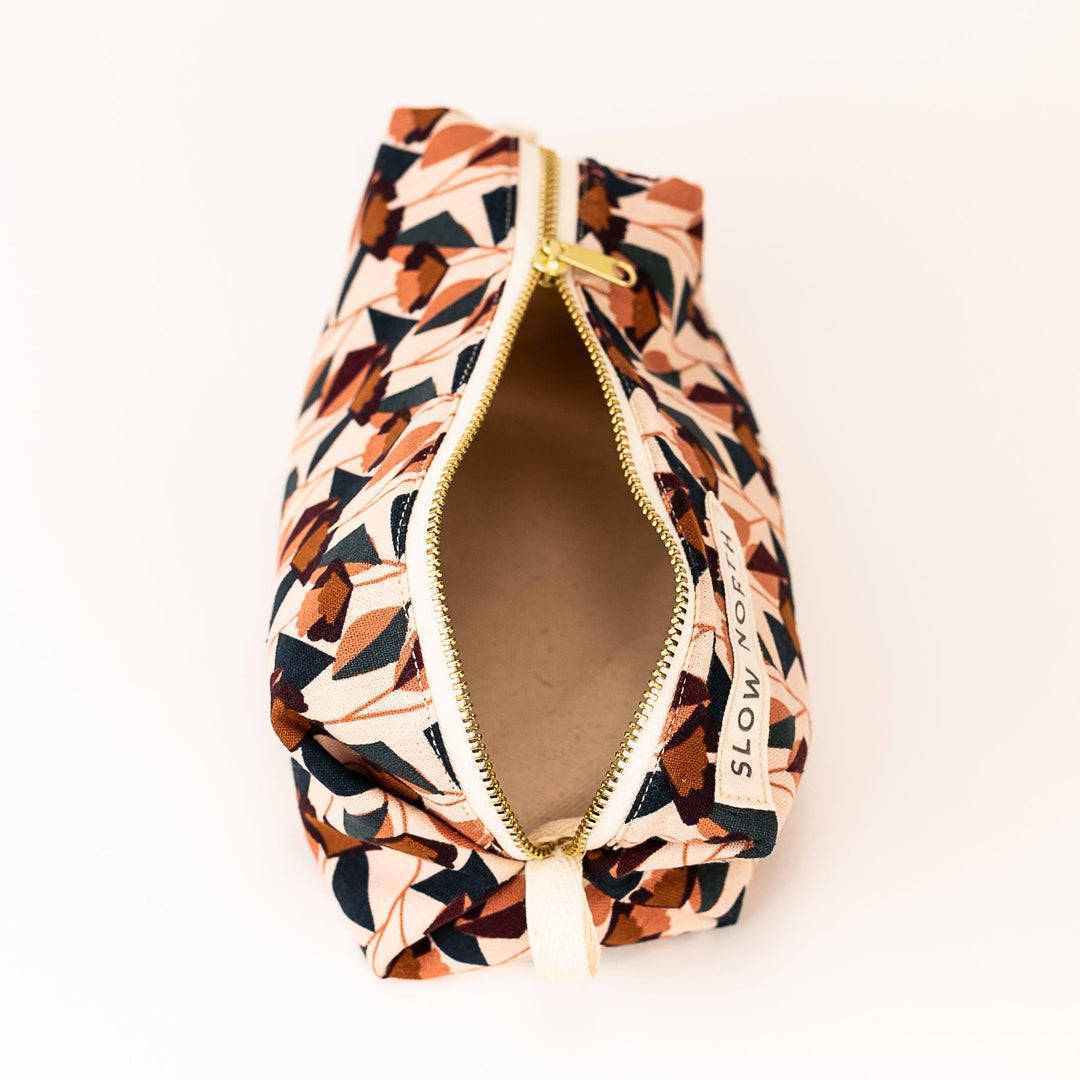 Blush cotton-linen pouch with floral motif and elegant compact design.